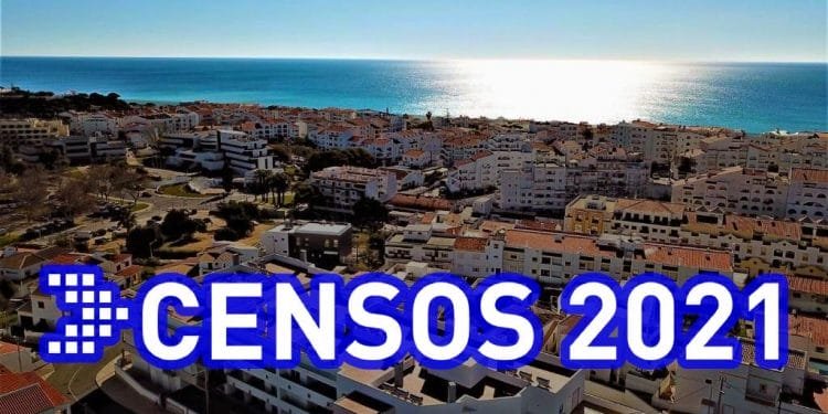 Una città costiera con numerosi edifici bianchi sotto un cielo limpido. Il sole sta tramontando o sorgendo sull'oceano calmo sullo sfondo. Il testo sovrapposto recita "Censos 2021" in grandi lettere blu e bianche.