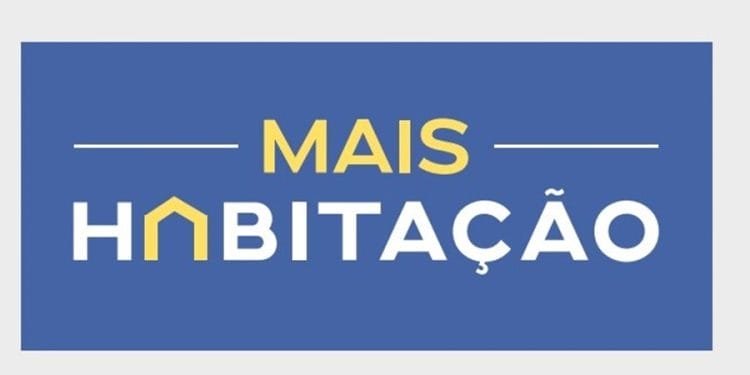 L'immagine presenta uno sfondo rettangolare blu con le parole "MAIS HABITAÇÃO" in testo giallo e bianco. La lettera "A" in "HABITAÇÃO" è stilizzata per assomigliare a una casa con il tetto giallo, a simboleggiare richieste di sostegno affitto per soluzioni abitative a prezzi accessibili.