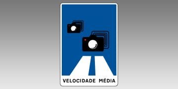 Un segnale stradale blu e bianco in Portogallo presenta due icone di telecamere che emettono onde di segnale, indicando autovelox. Dal basso si estendono due linee bianche che rappresentano una strada. Nella parte inferiore del cartello è riportata la dicitura "VELOCIDADE MÉDIA" (velocità media).