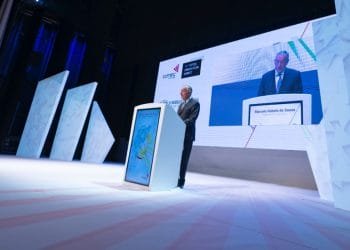 Un uomo sta dietro un podio su un grande palco ben illuminato. Un grande schermo accanto a lui mostra la sua immagine e il testo "Marcelo Rebelo de Sousa". Lo sfondo presenta pannelli astratti bianchi e loghi per "COTEC Portogallo" e "Portugal Covid-19 Response", evidenziando le collaborazioni con Italia e Spagna.