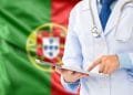Una persona che indossa un camice bianco e uno stetoscopio usa un tablet. Sullo sfondo è riprodotta la bandiera del Portogallo, con campi verdi e rossi e lo stemma nazionale, che evidenzia l'assistenza sanitaria portogallo.
