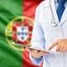 Una persona che indossa un camice bianco e uno stetoscopio usa un tablet. Sullo sfondo è riprodotta la bandiera del Portogallo, con campi verdi e rossi e lo stemma nazionale, che evidenzia l'assistenza sanitaria portogallo.