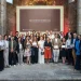 Un gruppo di persone, vestite con abiti business casual, sta in posa per la premiazione Best Of Wine Tourism in Porto 2026, tenendo in mano i diplomi. La foto è scattata al chiuso tra due imponenti muri e difronte ad un maxischermo.