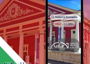 Smartphone che mostra i risultati della ricerca per "Italiani in Portogallo" sullo sfondo di un grande edificio rosso decorato con colonne bianche. Sullo schermo sono presenti due loghi, "AIReP" e "SPG", che evidenziano Serving People Group. Il testo nell'angolo in basso a sinistra recita "Italiani in Portogallo" su uno striscione verde e blu.