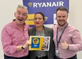 Annunciando nuovi voli Ryanair verso il Portogallo, Michael O'Leary solleva con entusiasmo un cartello blu con la scritta "ROMA 2024", "7 NUOVE ROTTE" e "RYANAIR".