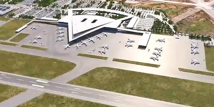 Veduta aerea del nuovo aeroporto di Lisbona con il caratteristico terminal a forma di stella. Intorno al terminal sono parcheggiati numerosi aerei. Le aree circostanti includono parcheggi, strade di accesso e terreni non edificati. Una pista si incrocia davanti al terminal.