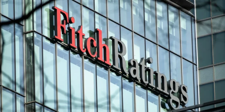 Un edificio con facciata in vetro riflettente mostra il logo Fitch Ratings in evidenza a grandi lettere in Portogallo. La parola Fitch è in rosso e Ratings è in nero.