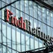 Un edificio con facciata in vetro riflettente mostra il logo Fitch Ratings in evidenza a grandi lettere in Portogallo. La parola Fitch è in rosso e Ratings è in nero.