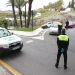 Gli agenti della polizia stanno cominando una multa del traffico su una strada in Spagna, che sarà poi da pagare. Con l'auto della polizia parcheggiata di lato, gli agenti con i giubbotti ad alta visibilità parlano con gli automobilisti.