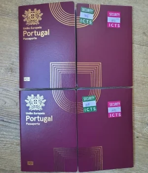 Quattro passaporti portoghesi, con il design Nuovo Passaporto elettronico portoghese, poggiano su una superficie di legno. Due espongono adesivi "Security ICTS". Le copertine color marrone sono elegantemente goffrate con testo dorato ed elementi di design, riflettendo un mix di tradizione e modernità.