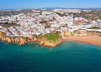 Adagiata lungo una spiaggia sabbiosa, di Albufeira città con i suoi edifici bianchi densamente ammassati su una collina si affaccia sull'oceano turchese. Circondata da verdi colline e un cielo azzurro e limpido, Albufeira vanta scogliere mozzafiato lungo la sua costa.