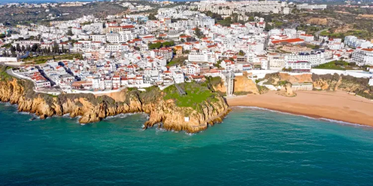 Adagiata lungo una spiaggia sabbiosa, di Albufeira città con i suoi edifici bianchi densamente ammassati su una collina si affaccia sull'oceano turchese. Circondata da verdi colline e un cielo azzurro e limpido, Albufeira vanta scogliere mozzafiato lungo la sua costa.