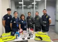 Un gruppo di sei doganieri, in uniforme, sta dietro un tavolo su cui sono esposti vari oggetti confiscati. Gilet ad alta visibilità con la scritta "Dogane" e "Guardia di Finanza" sono drappeggiati sul tavolo in seguito al recente sequestro di cocaina tra Lisbona e Firenze che ha portato a un arrestato.
