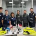Un gruppo di sei doganieri, in uniforme, sta dietro un tavolo su cui sono esposti vari oggetti confiscati. Gilet ad alta visibilità con la scritta "Dogane" e "Guardia di Finanza" sono drappeggiati sul tavolo in seguito al recente sequestro di cocaina tra Lisbona e Firenze che ha portato a un arrestato.