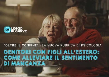 Una coppia di genitori anziani è seduta l'una accanto all'altra su un divano e sorride allo smartphone mentre effuttuano una videociamata ai figli al estero alleviando così il sentimento di mancanza. Il testo recita: "Genitori con figli all'estero: la psicologia svela come affrontare il sentimento di mancanza". L' ambiente appare caldo e accogliente.