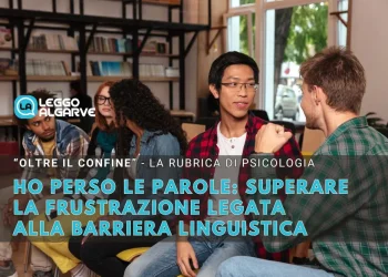 Un gruppo di ragazzi, superando le difficoltà della barriera linguistica, siedono in un ambiente informale al chiuso, con persone che parlano mentre altri ascoltano attentamente. Scaffali pieni di libri sono sullo sfondo, a sottolineare la loro ricerca di superare la frustrazione e condividere i loro sentimenti.