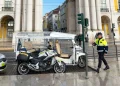 Un tuk-tuks parcheggiato a Lisbona e un poliziotto che si accinge ad emettere la multa. Si vede anche una moto e dei palazzi antichi sullo sfondo.
