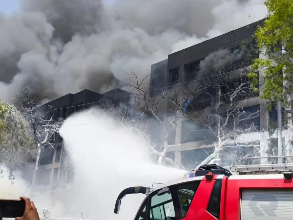 Un palazzo in India brucia con del fumo dopo l'incidente aereo in cui sono coinvolti sette portoghesi. 