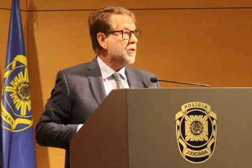 Luís Neves direttore della PJ Portogallo parla durante la conferenza stampa lanciando l'allarme estrema destra. È visibile una bandiere e il logo della Policia Judiciaria.