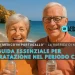 Due persone anziane sorridenti con occhiali da sole con delle bottigliette di acqua in mano a simboleggiare l'importanza di idratarsi nei periodi calid. L'ambientazione è una spiaggia dell'Algarve con il mare e il cielo azzurro di sfondo.