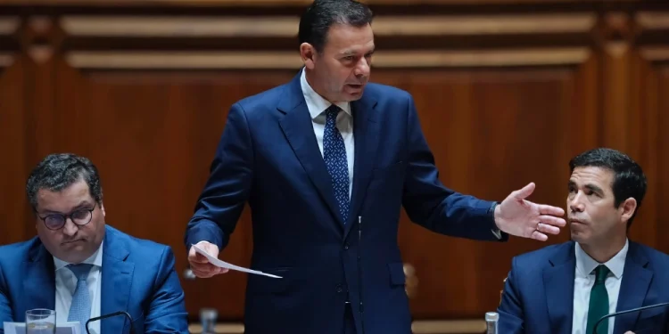 Joaquim Miranda Sarmento, Luís Montenegro e Leitão Amaro in parlamento mentre discutono della riduzione dell IRS 2025.