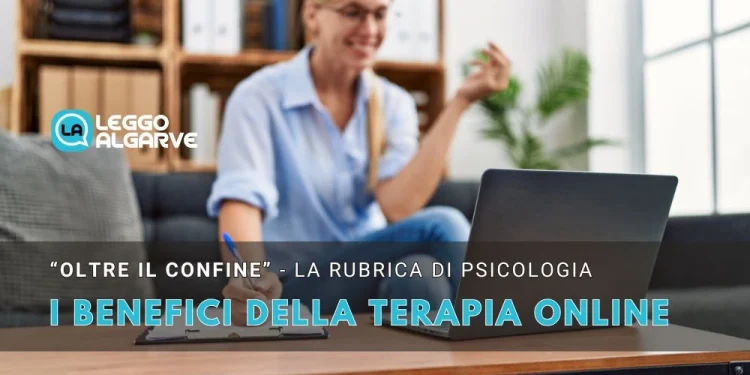 Una donna è seduta a un tavolo, sorride e gesticola durante una videochiamata con un computer portatile. Il testo in italiano sull'immagine evidenzia i benefici della terapia online in un ambiente domestico confortevole.