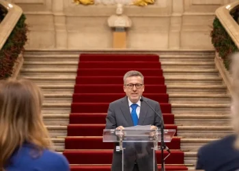 Carlos Moedas sindaco di Lisbona parla sullo sfondo di una scalinata con tappeto rosso difronte ad alcune persone di spalle.