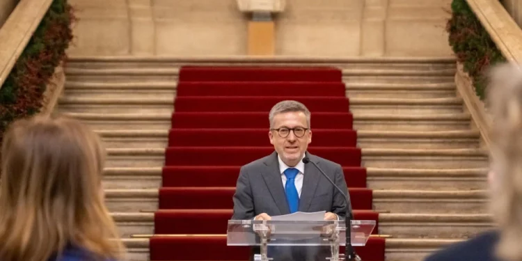 Carlos Moedas sindaco di Lisbona parla sullo sfondo di una scalinata con tappeto rosso difronte ad alcune persone di spalle.