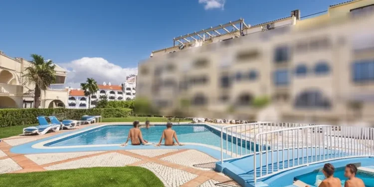 Una piscina in un complesso turistico sfuocato dove i due britannici annegano durante le vacanze. Alcune persone sono stanno prendendo il sole.