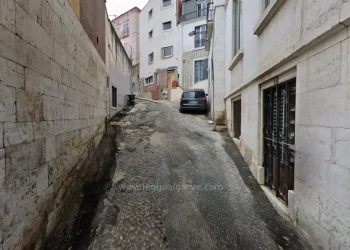 La strada Pátio do Salema di Lisbona dove è stato ritrovato il cadavere senza testa, con palazzi in fase di ristrutturazione, auto parcheggiata e grate alle finestre.
