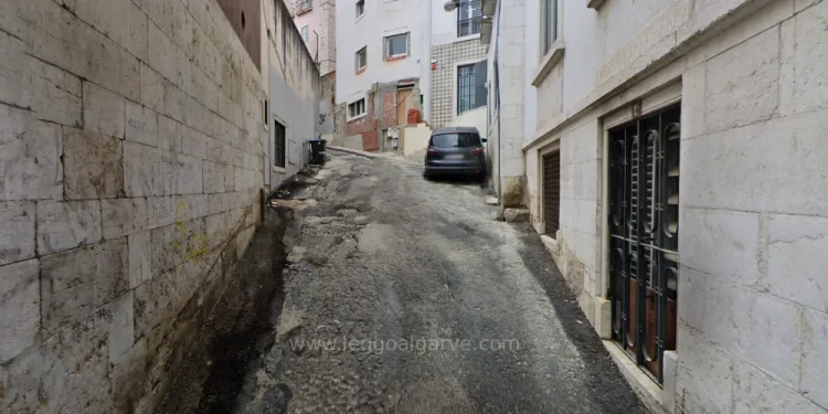 La strada Pátio do Salema di Lisbona dove è stato ritrovato il cadavere senza testa, con palazzi in fase di ristrutturazione, auto parcheggiata e grate alle finestre.