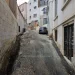 La strada Pátio do Salema di Lisbona dove è stato ritrovato il cadavere senza testa, con palazzi in fase di ristrutturazione, auto parcheggiata e grate alle finestre.