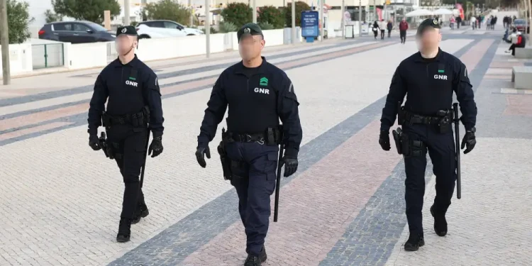 Tre poliziotti della GNR in Portogallo che pattugliano i comuni più pericolosi. Sono in mezzo ad una strada dell'Algarve a piedi.