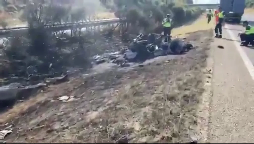 Immagine con i resti dell'auto carbonizzata dove è morto Diogo Jota con il fratello André Silva. Lo scenario è il ciglio di una strada in Spagna con dei poliziotti intenti a effettuare i rilievi di legge.