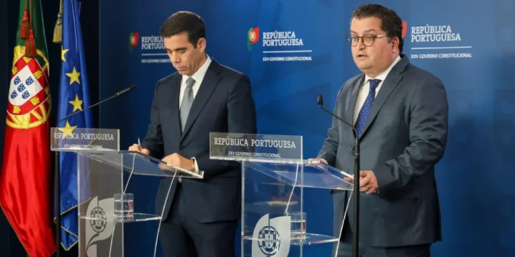 I ministri Miranda Sarmento e Leitão Amaro, alla conferenza stampa per annunciare le nuove misure a favore dei pensionati e delle imprese. Si vedono le bandiere del Portogallo e della UE.