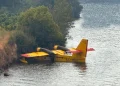 Un aereo Canadair EC-HEU in avaria che galleggia sul fiume Douro in Portogallo, nei pressi della riva con una folta vegetazione di piante.