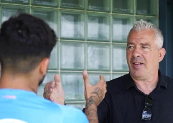 Jorge Costa guarda un giocatore del Porto di spalle sullo sfondo di una parete di vetro.