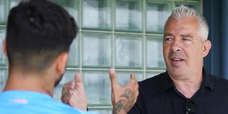 Jorge Costa guarda un giocatore del Porto di spalle sullo sfondo di una parete di vetro.