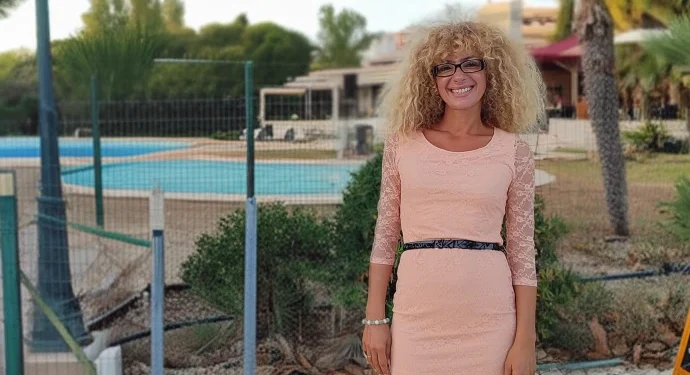 Silvana di Liberto in posa di fronte ad un giardino con piscina in Algarve ed una casa sullo sfondo.