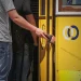 Vicino ad un tram giallo di Lisbona, un borseggiatore sfila un portafoglio nero dalla tasca di un uomo.