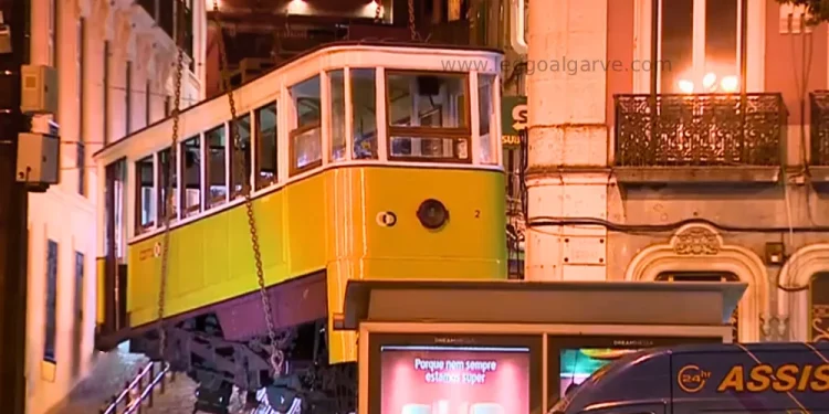 Una vettura della Funicolare di Lisbona deragliata che viene rimossa durante la notte sollevandola da terra, per consentire indagini più specifiche.