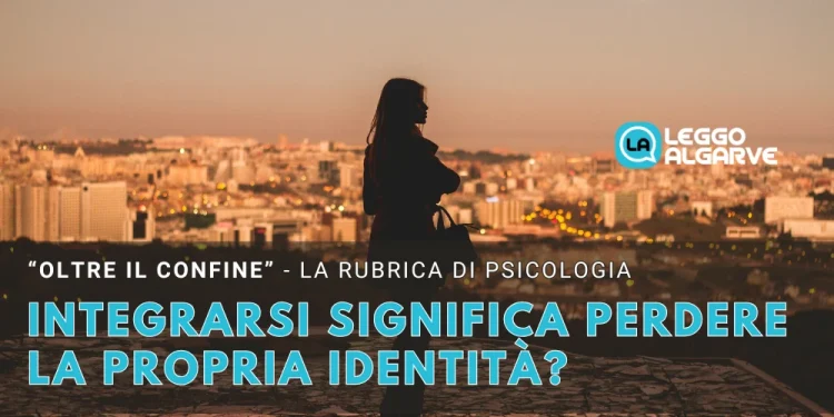 Una sagoma di donna in piedi su una collina che domina la città di Lisbona al tramonto, con testo italiano su psicologia, identità e integrazione dopo l' espatrio da "Leggo Algarve.