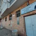 Esterno di un edificio in mattoni della moschea di Lisbona oggetto di minaccia, "Masjid (Moschea) Sayyidina Abu Bakr Siddiq (R.A.)" in inglese e arabo, con doppie porte bianche, finestre e marciapiede.