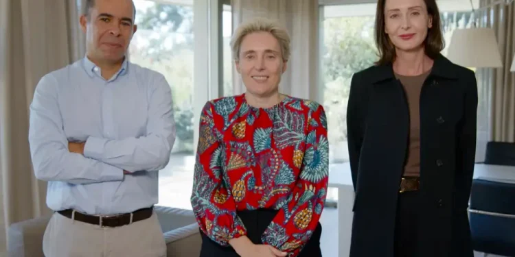 Miguel Mota Freitas, il nuovo CEO di Worten Claudia Azevedo, al centro e Minette Bellingan posano in piedi in un salotto con delle finestre sullo sfondo.