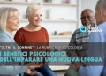 I benefici di imparare una nuova lingua dove quattro adulti anziani siedono in cerchio, sorridendo e parlando, in una stanza luminosa. Il testo in italiano evidenzia i benefici di imparare una nuova lingua per il benessere psicologico.