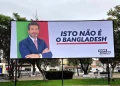 Un cartellone politico legato a Chega mostra un uomo in giacca e cravatta a braccia conserte su sfondo verde e rosso. Il testo in portoghese recita "ISTO NÃO É O BANGLADESH", scatenando polemiche sui manifesti di Andre Ventura per le Presidenciais 2021.