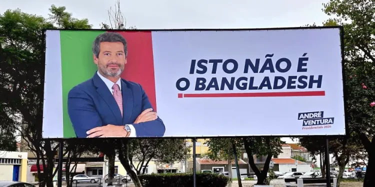 Un cartellone politico legato a Chega mostra un uomo in giacca e cravatta a braccia conserte su sfondo verde e rosso. Il testo in portoghese recita "ISTO NÃO É O BANGLADESH", scatenando polemiche sui manifesti di Andre Ventura per le Presidenciais 2021.