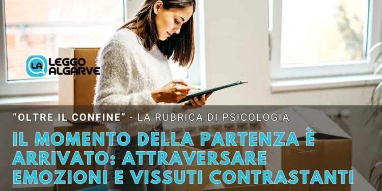 Una donna in piedi accanto a scatoloni, intenta a leggere dei fogli. Un testo in italiano si sovrappone all'immagine, riflettendo sulle sfide emotive affrontate nel momento della partenza e del trasferimento, per una rubrica di psicologia di Leggo Algarve. Finestre luminose illuminano l'ambiente moderno.