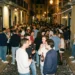 Una folla di giovani si riunisce durante la movida notturna a Lisbona, dove in alcune zone sono vietati alcolici consumati in strada, mentre sorseggiano birre e chiacchierano tra i vicoli storici del Bairro Alto caratterizzati da graffiti e sampietrini.