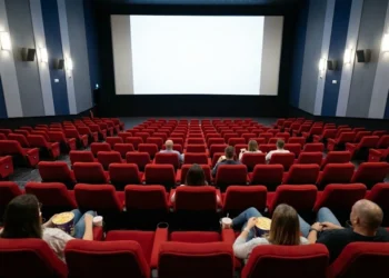 Una sala cinema in Portogallo in crisi perché vi sono poche persone sulle poltroncine rosse. Le pareti sono in stile moderno con colori blu e azzurri e le luci sono accese e sullo schermo non è proiettato il film.
